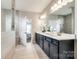 Bright bathroom with double vanity, quartz countertops, and an open door leading to the bedroom at 1625 Carolina Orchards Blvd, Fort Mill, SC 29715
