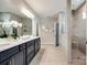 Bright bathroom featuring double vanity, a large mirror, and a glass-enclosed shower with tiled walls at 1625 Carolina Orchards Blvd, Fort Mill, SC 29715