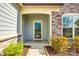 Inviting front porch featuring stone accents and a glass front door, surrounded by manicured landscaping at 1625 Carolina Orchards Blvd, Fort Mill, SC 29715