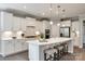 Modern kitchen boasts white cabinetry, stainless steel appliances, quartz countertops, and an island with bar seating at 1625 Carolina Orchards Blvd, Fort Mill, SC 29715