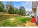 Large, grassy backyard with a patio area, grill, and a black metal fence backing up to a wooded area at 200 Boysenberry Dr, China Grove, NC 28023
