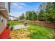 Fenced-in backyard features a patio with a grill, landscaping, and a view of the surrounding trees at 200 Boysenberry Dr, China Grove, NC 28023
