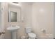 Powder room featuring a pedestal sink, white toilet and neutral walls at 200 Boysenberry Dr, China Grove, NC 28023