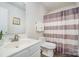 Bright bathroom featuring a single sink vanity, toilet, mirror, and shower with striped curtain at 2005 Dunsmore Ln, Waxhaw, NC 28173