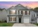Charming two-story home with gray siding, black shutters, a well-kept lawn, and attached garage at sunset at 2005 Dunsmore Ln, Waxhaw, NC 28173