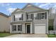 Two-story home featuring gray siding, black shutters, and an attached garage at 2005 Dunsmore Ln, Waxhaw, NC 28173
