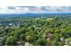 Aerial view showcasing the property within a wooded neighborhood with Charlotte city skyline views at 2038 Sandhurst Dr, Charlotte, NC 28205