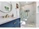 Beautiful bathroom featuring a marble countertop, blue vanity, and luxurious shower with glass door at 2038 Sandhurst Dr, Charlotte, NC 28205