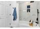 Newly renovated bathroom with a shower-tub combination featuring modern tile, black fixtures, and a decorative plant at 2038 Sandhurst Dr, Charlotte, NC 28205