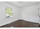 Bright bedroom with hardwood floors, fresh paint, a window with tree views, and a closet at 2038 Sandhurst Dr, Charlotte, NC 28205
