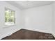 A room with dark hardwood flooring, one double-hung window, and white walls at 2038 Sandhurst Dr, Charlotte, NC 28205