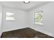 A room with dark hardwood flooring, two double-hung windows, and white walls at 2038 Sandhurst Dr, Charlotte, NC 28205