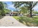 Charming exterior view of a single-story home with mature trees, a driveway, and well-kept lawn at 2038 Sandhurst Dr, Charlotte, NC 28205