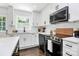 Updated kitchen features white cabinetry, stainless steel appliances, and modern finishes at 2038 Sandhurst Dr, Charlotte, NC 28205