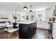 Open-concept kitchen with a center island, modern pendant lighting, stainless steel appliances, and white cabinetry at 2038 Sandhurst Dr, Charlotte, NC 28205
