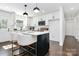 Eat-in kitchen featuring a center island with bar seating, white cabinetry, and sleek modern pendant lighting at 2038 Sandhurst Dr, Charlotte, NC 28205