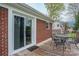 Back deck with metal table and chairs. Sliding door leads to brick home at 205 Gamble Ave, Bessemer City, NC 28016