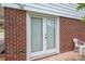Exterior view of brick home featuring double doors and a white chair, adding a cozy touch at 205 Gamble Ave, Bessemer City, NC 28016