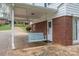 Inviting covered porch with a swing, providing a relaxing outdoor seating area with a brick exterior at 205 Gamble Ave, Bessemer City, NC 28016