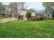 Exterior view of a brick and white home with a large yard and covered patio at 205 Gamble Ave, Bessemer City, NC 28016