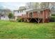 Exterior view of a brick and white home with a wooden deck and storage shed at 205 Gamble Ave, Bessemer City, NC 28016