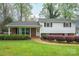 Traditional home featuring manicured landscaping, a brick facade, and white siding at 205 Gamble Ave, Bessemer City, NC 28016