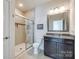 Well-lit bathroom featuring a tiled shower with glass door, toilet, and vanity with sink at 2052 Donaldson St, Indian Land, SC 29707