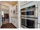Modern kitchen showcasing stainless steel double ovens, white cabinetry, and granite countertops next to the dining room at 2052 Donaldson St, Indian Land, SC 29707