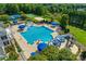 Aerial view of a community pool with a slide, tennis courts, sand volleyball court and well-manicured lawn at 2052 Donaldson St, Indian Land, SC 29707