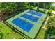 Aerial shot of three well-maintained blue and green tennis courts surrounded by trees and greenery at 2052 Donaldson St, Indian Land, SC 29707