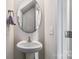 Stylish half-bathroom features a pedestal sink, a modern mirror, and a clean, minimalist design at 213 Morton St, Shelby, NC 28152