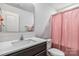 Cozy bathroom featuring a modern vanity, ample mirror, and a shower with a pink curtain at 213 Morton St, Shelby, NC 28152