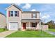 Charming two-story home with a well-maintained lawn, a garage, and a welcoming front porch with red door and shutters at 213 Morton St, Shelby, NC 28152
