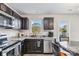 Well-equipped kitchen with stainless steel appliances, dark cabinetry, granite countertops, a window, and a dining area at 213 Morton St, Shelby, NC 28152