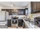 Functional kitchen with stainless steel appliances, dark cabinets, granite countertops, and a view overlooking the dining area at 213 Morton St, Shelby, NC 28152