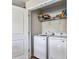 Convenient laundry area with white, front-load washer and dryer and extra storage on shelving at 213 Morton St, Shelby, NC 28152