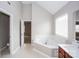 Bright bathroom featuring a soaking tub with a large window and tiled floors at 240 Bluffton Rd, Mooresville, NC 28115
