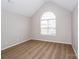 Cozy bedroom featuring a vaulted ceiling, large window, and neutral carpeting at 240 Bluffton Rd, Mooresville, NC 28115