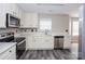 Bright kitchen featuring stainless steel appliances, white cabinets and modern countertops at 240 Bluffton Rd, Mooresville, NC 28115