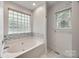 Bathroom featuring a luxurious soaking tub with a glass block window for privacy and natural light at 2470 Highway 557 Rd, Clover, SC 29710