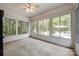 Bright sunroom with large windows offering serene views of the wooded backyard and access to outdoor amenities at 2470 Highway 557 Rd, Clover, SC 29710