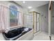 Elegant bathroom featuring a black soaking tub by a large window and glass-enclosed shower at 252 Greyfriars Rd, Mooresville, NC 28117