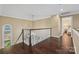 Hallway with hardwood floors, staircase with white railing, and chandelier at 252 Greyfriars Rd, Mooresville, NC 28117