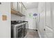 Bright laundry room with modern washer, dryer, storage cabinets, and ironing board at 252 Greyfriars Rd, Mooresville, NC 28117
