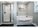 Bathroom showcasing a glass-enclosed shower and a soaking tub with an elegant decor at 2676 Poplar Cove Nw Dr, Concord, NC 28027