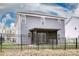 Backyard view of this two-story home, featuring a screened patio and an elegant black fence at 2676 Poplar Cove Nw Dr, Concord, NC 28027