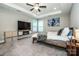 Bright main bedroom features a ceiling fan, tray ceiling, accent wall, and a large window at 2676 Poplar Cove Nw Dr, Concord, NC 28027
