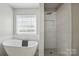 Bright bathroom featuring a soaking tub beneath a window and a spacious tiled shower at 2945 Christian Scott Ln, Charlotte, NC 28214