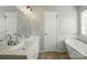 Bathroom featuring double sinks, a modern bathtub, and hardwood floors at 2945 Christian Scott Ln, Charlotte, NC 28214