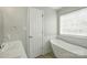 Bright bathroom featuring a modern bathtub, hardwood floors, and a window at 2945 Christian Scott Ln, Charlotte, NC 28214